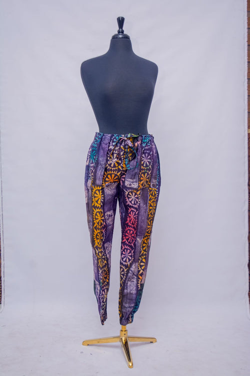 African Batik Tapered Jogger Pants — Purple & Gold Sunwheel Medallion Print with Drawstring Waist, full front view
